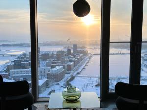 Luxury Skyscraper Apartment with Amazing view over Helsinki في هلسنكي: غرفة مطلة على مدينة في الثلج
