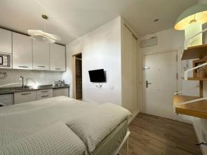 um quarto branco com uma cama e uma cozinha em Tu estudio en el centro de Madrid em Madrid