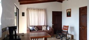 ein Wohnzimmer mit einem Sofa und einem Tisch in der Unterkunft Casa Finca Lindora in Monteverde Costa Rica