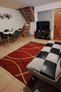 sala de estar con sofá, mesa y TV en Cómodo departamento full equipado en Coyhaique, en Coyhaique