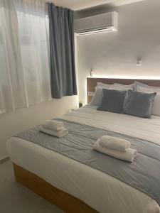 een slaapkamer met een groot bed en 2 handdoeken bij Athens Cosy Semi-Basement Apartment in Athene