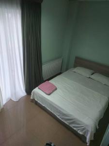 een slaapkamer met een bed met een roze handdoek erop bij Wonderful_place_for 2 persons in Tbilisi City