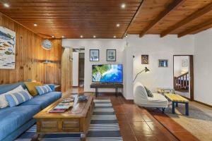 Lighthouse Tinajo في تيناجون: غرفة معيشة مع أريكة زرقاء وتلفزيون