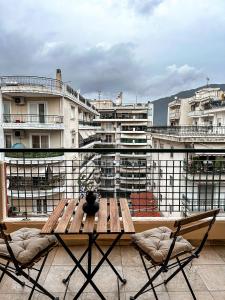 una mesa y sillas en un balcón con edificios en JP Luxury Apartment in citycenter, en Xanthi