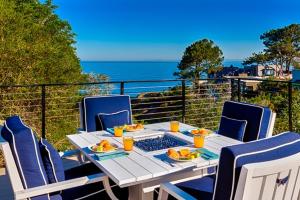 a table with plates of food on top of a balcony at Endless Vistas On The Cove Perfection - Spa, Pet-Friendly, Stunning Views, Large Parking & AC in San Diego