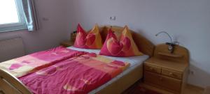 a bedroom with a bed with pink sheets and pillows at Ferienwohnung by Pfleger's in Ulrichsberg