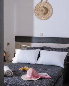 a bed with a plate of food and a hat on it at Stella Apartment in Kaloi Limenes