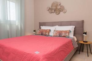a bedroom with a large bed with a red blanket at Virginia's Luxury Suite 4 in Volos