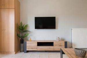 a living room with a television on a white wall at Virginia's Luxury Suite 4 in Volos