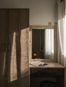 a desk with a mirror and a book on it at Stella Apartment in Kali Limenes