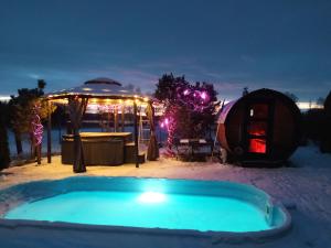 a hot tub in the snow next to a yurt at Dom na Mazurach z jacuzzi, balią i sauną in Stare Juchy