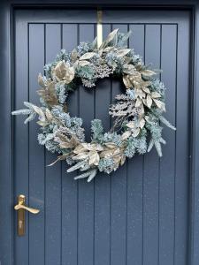 Una corona de Navidad está colgada en una puerta en Ysgubor Twt, Monknash, en Monknash