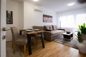 a living room with a table and a couch at Apartman IVANA - private parking in Osijek