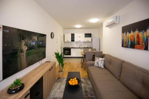 a living room with a couch and a table at Apartman IVANA - private parking in Osijek