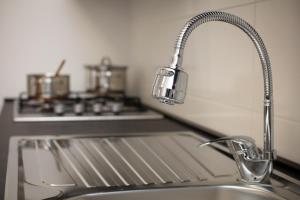 a kitchen sink with a faucet next to a stove at Apartman IVANA - private parking in Osijek +40 photos