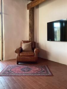 a brown chair sitting in a living room with a television at Willow Street Cottages in Bluff