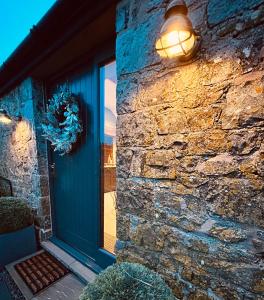 a door with a light on the side of a building at Ysgubor Twt, Monknash in Monknash