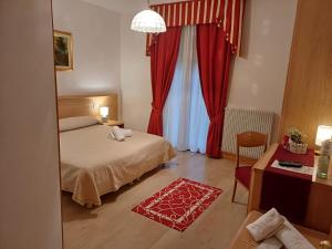 a bedroom with a bed and red curtains at Albergo Dalla Mena in Romano D'Ezzelino