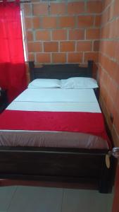uma cama num quarto com uma parede de tijolos em Hotel campestre la isla em Neiva