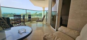 a living room with a glass table and chairs at De Golf Luxury Resort Apartments in Eilat