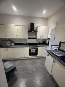 a kitchen with white cabinets and a stove top oven at M&B Accommodation in Lincoln
