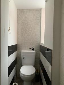 ein Badezimmer mit einem weißen WC und einer gefliesten Wand in der Unterkunft M&B Accommodation in Lincoln