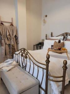 a bedroom with a bed with a bench and clothes at City Center Suites in Karpathos