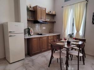 a kitchen with a table and a white refrigerator at City Center Suites in Karpathos