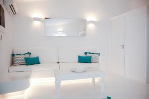 a white living room with a white couch and a table at The Turquoise House in the heart of Ioulida, on the island of Kea. in Ioulis