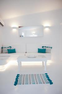 Habitación blanca con mesa y alfombra en el suelo en The Turquoise House in the heart of Ioulida, on the island of Kea. en Kéa