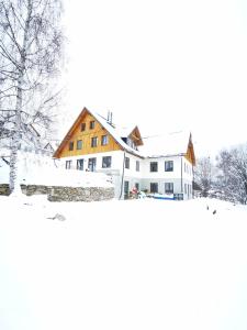 a large white house in the snow at Rock-inn in Rokytnice nad Jizerou