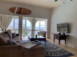 a living room with a couch and a flat screen tv at Breathtaking ocean views in Judiths Fancy in La Grande Princesse