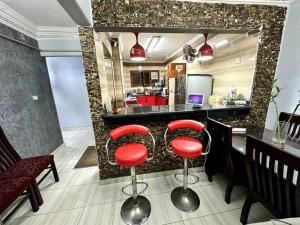 a kitchen with two red bar stools in front of a counter at Sanctuary in Cairo