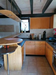 une cuisine avec des armoires en bois et un comptoir dans l'établissement Ferienhaus romantisches Cottage - 2 Schlafzimmer und 2 Bäder - auf historischer Hofreite, à Gründau