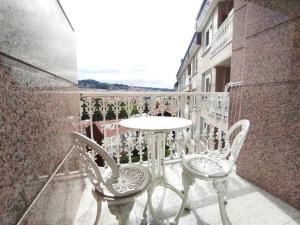 uma mesa e cadeiras numa varanda com vista em Espectaculares vistas Mirador Alameda con Garaje em Ourense