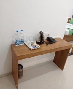 a wooden table with water bottles and glasses on it at Eon IT Park Corporate Hotel in Pune
