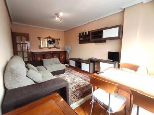 uma sala de estar com um sofá e uma mesa em Espectaculares vistas Mirador Alameda con Garaje em Ourense