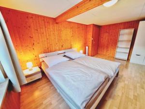 um quarto com uma cama grande e uma parede de madeira em Höflihaus, Maienfeld em Maienfeld