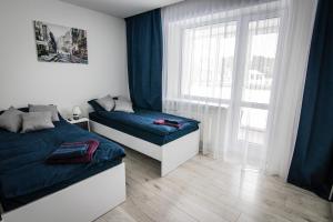 a bedroom with two beds and a window at Ramūs apartamentai in Anykščiai