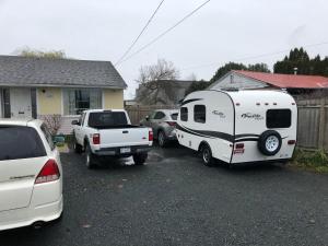 une remorque blanche est garée dans un parking dans l'établissement Shady Willow Guest House -Coach house & Privet Small Compact Rooms with separate entrance, à Chilliwack