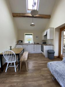 a kitchen and living room with a table and chairs at Unique Stay on an Alpaca Therapy Farm with Miniature Donkeys North Wales in Mold