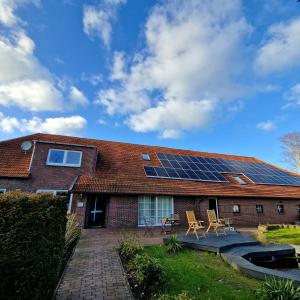 ein Haus mit Sonnenkollektoren auf dem Dach in der Unterkunft Moorparadies FRI-Südliches Friesland in Bockhorn