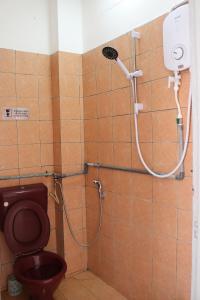 uma casa de banho com duche, WC e cabeça de chuveiro em Swanling Kuching em Kuching