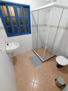 a bathroom with a shower and a toilet and a sink at Pousada Jardins in Macaé
