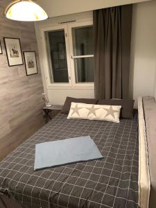 a bedroom with a bed with a blue sheet on it at Villa Haantie in Längelmäki