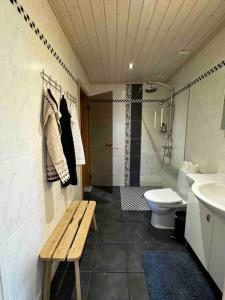 a bathroom with a bench and a toilet and a sink at Feriehus med ti senger på Skaidi in Hammerfest