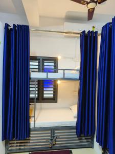 Zimmer mit blauen Vorhängen und einem Etagenbett in der Unterkunft Marhaba family dormitory in Kozhikode