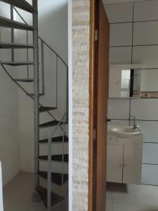 a staircase leading up to a bathroom with a sink at Kitnet da Fô in Pelotas