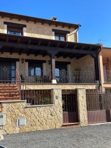 Casa de piedra con puerta y balcón en Casa rural Con Calma, en Zarzuela del Monte