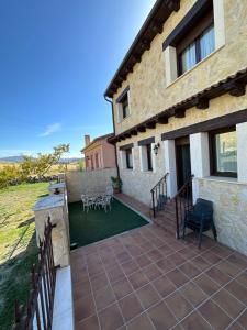 un patio de una casa con mesa y sillas en Casa rural Con Calma, en Zarzuela del Monte